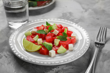 Plate with delicious watermelon salad on table