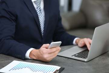 Businessman using mobile phone while working in office