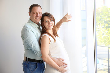 Happy young couple near window