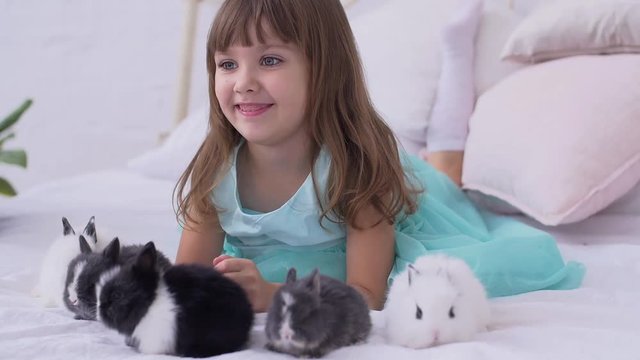 Pretty teen girl having fun, hugging and playing with decorative rabbit