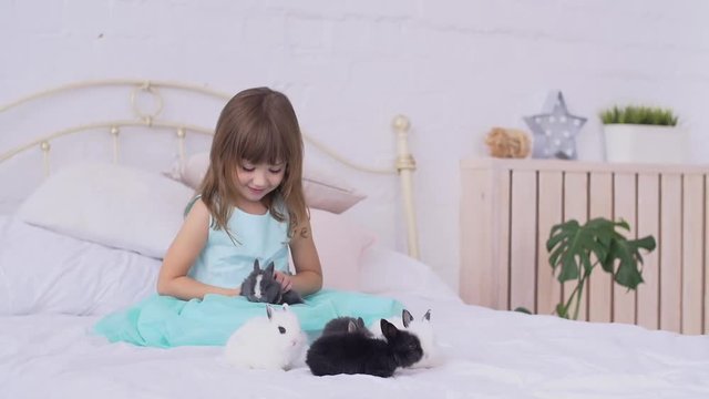 Pretty teen girl having fun, hugging and playing with decorative rabbit