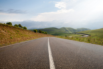 Asphalt flat road winding along the slopes of high mountains in the Elbrus region