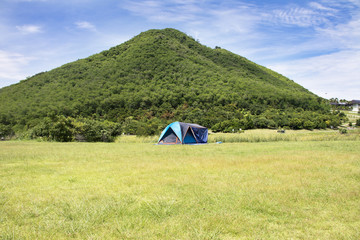 Fototapeta na wymiar Travelers people build tent camping on grass field for rest and sleep near mountain at Chang Hua Man Royal Initiative and Agricultural Project