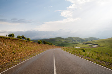 Asphalt flat road winding along the slopes of high mountains in the Elbrus region