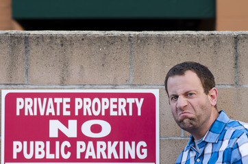 Man upset but a "No Parking Sign" outside with an angry expression.