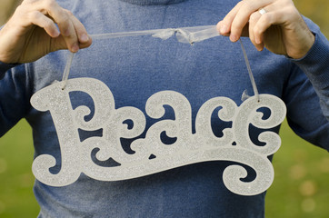 Peace at Christmas! Man holding a Peace sign, holding torso and hands are showing no face.