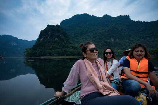 asian woman toothy smiling face happiness emotion sailing boat in ninh binh canal most popular traveling destination in vietnam
