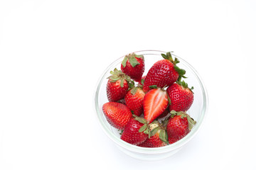The many strawberries in glass cup on white background , isolated