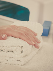 Woman hand on towel, next to manicure set