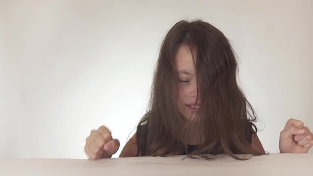 Beautiful sad teenage girl rolls a fit and freaks out on white background stock footage video