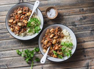 Cannellini beans beef stew with couscous on the wooden table, top view. Autumn, winter seasonal, healthy comfort food