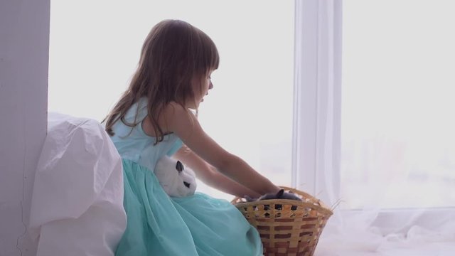 Pretty teen girl having fun, hugging and playing with decorative rabbit