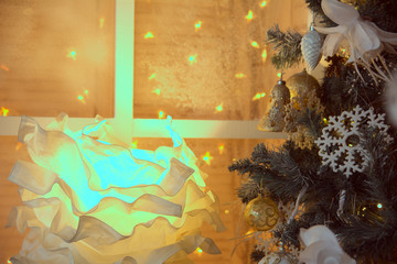 Decoration with a Christmas tree and a background of burning garlands. Paper glowing flower