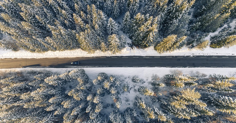 Black car on road in winter scenery, from above.