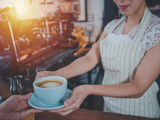 Young beautiful asian women barista giving coffee to customer at coffee shop, Cafe restaurant service concept,Owner small business concept.