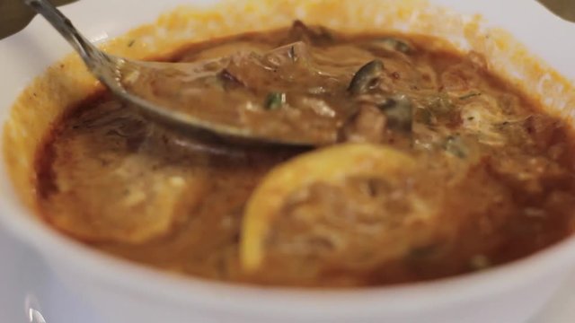 stir soup with a spoon, soup with lemon and olives