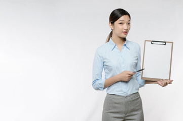 Young Asian business woman point to blank clipboard isolated on white background