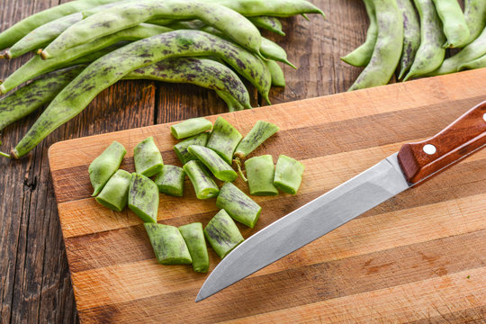 Slicing beans on cutting board, cooking