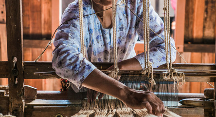 The local Intha woman weaving the lotus cloth with the hand loom at the local lotus cloth weaving...
