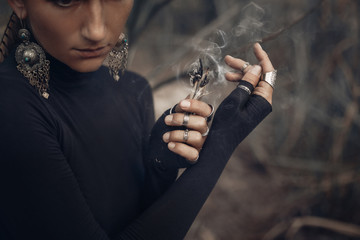 close up of young woman hands holding incense