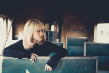 Fototapeta premium Portrait of asian woman golden hair pose for take a photo on old train vintage style,thailand people,Lifestyle of modern girl