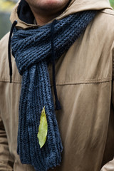 Single leaf stick to the mans scarf during walk