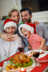 cheerful family taking selfie for Christmas.