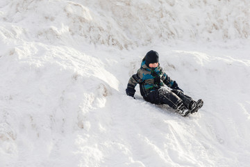 Fototapeta na wymiar Small boy walking the mountain in deep snow