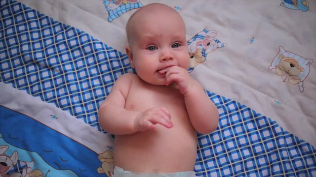 Cute baby lies on back and smiling (closeup) 