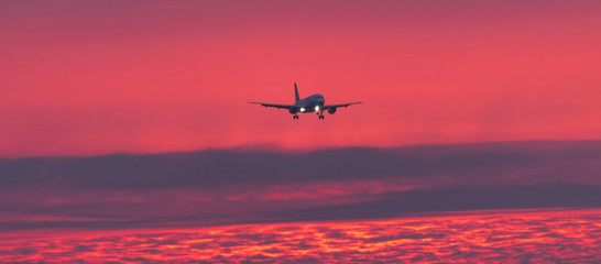 airplane landing at an airport in an evening sundown