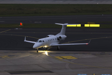 small passenger jet airplain at an airport in the evening