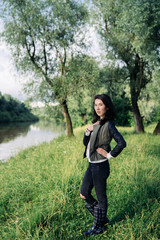 girl walking on the grass near the river in a forest outdoor