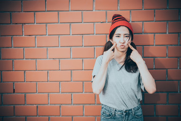 Portrait asian hipster girls on brick wall background,Hippie dress style,Thailand modern woman lifestyle,Beauty fashion portrait outdoor