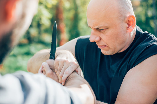 Kapap instructor demonstrates martial arts self defense knife attack disarming