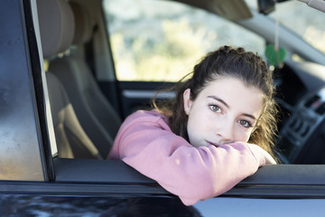 Fototapeta na wymiar Teenage girl looking out the window of her car