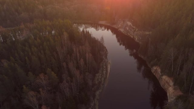 Drone tilt up revealing forests, twisty river bends and sandstone cliffs of Gauja Natonal Park, Latvia