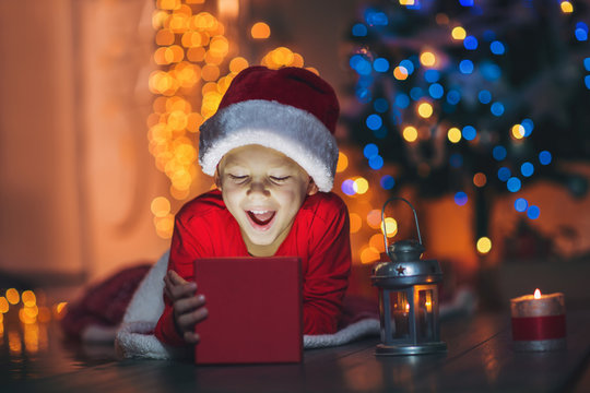 Surprised Child Opening Magic Christmas Present. Xmas Holiday Concept