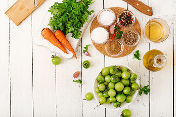 Ingredients for Korean salad from green tomatoes and carrots. Flat lay. Top view