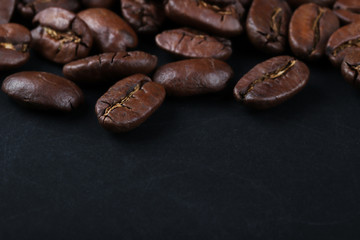  cracked grains of black fried coffee. slate background