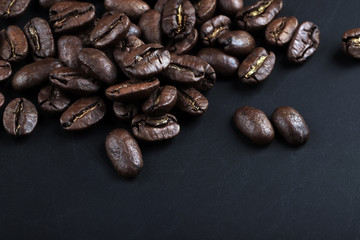  cracked grains of black fried coffee. slate background