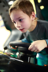 Preschooler playing in car simulator