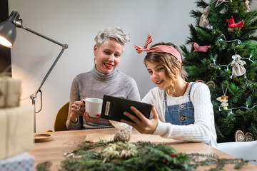 Mother and daughter watching on tablet for new year presents ideas