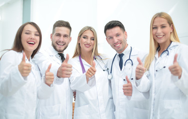 Portrait of a doctor and medical team showing thumb up