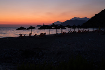 Dusk scenery with umbrellas over albanian sea
