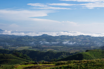 Fototapeta premium Landscape, clouds in the sky, thin mist and mountains with trees.