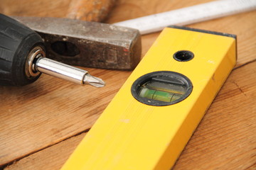 Hammer und Wasserwaage auf einem Holzbrett