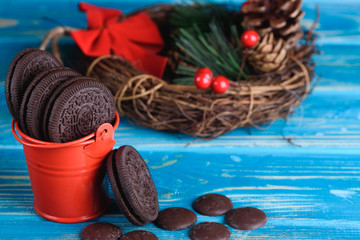 Decorative red pail with chocolate cookies on the table