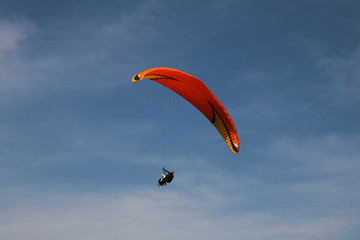  paraglider is flying in the blue sky against the background of clouds. Paragliding in the sky on a sunny day.