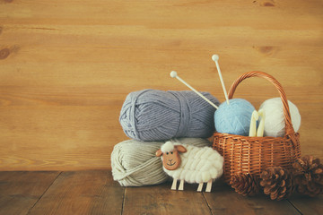 warm and cozy yarn balls of wool on wooden table.