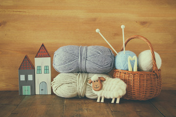 warm and cozy yarn balls of wool on wooden table.